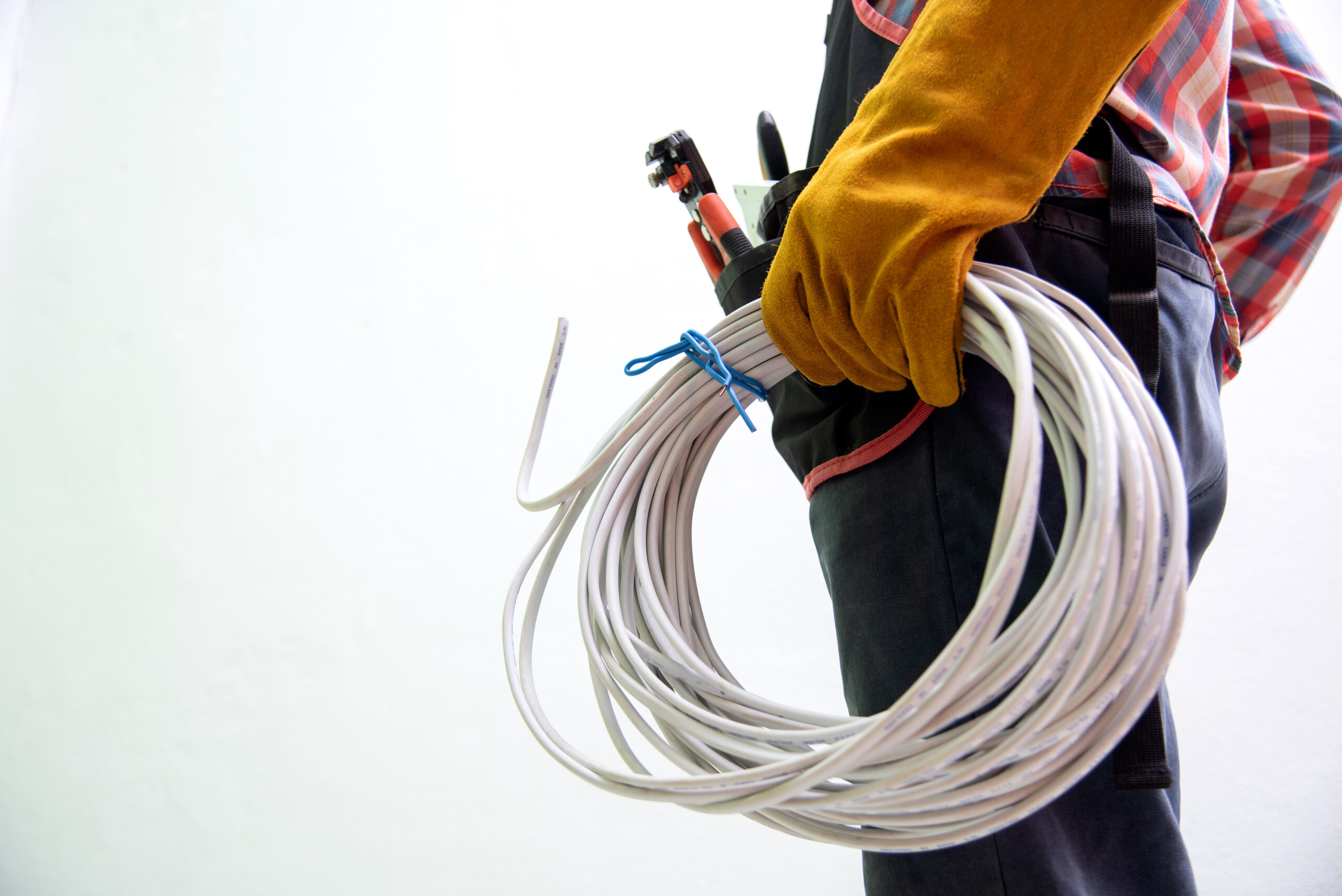 electrician fixing the light inside remodeled apartment. construction theme caucasian electrician in yellow safety hard hat at work. reinstallation of residential electrical system.